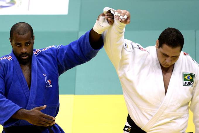 Teddy Riner de azul com o braço erguido pelo árbitro ao lado de Rafael Silva, de branco, na final do Mundial do Rio de 2013